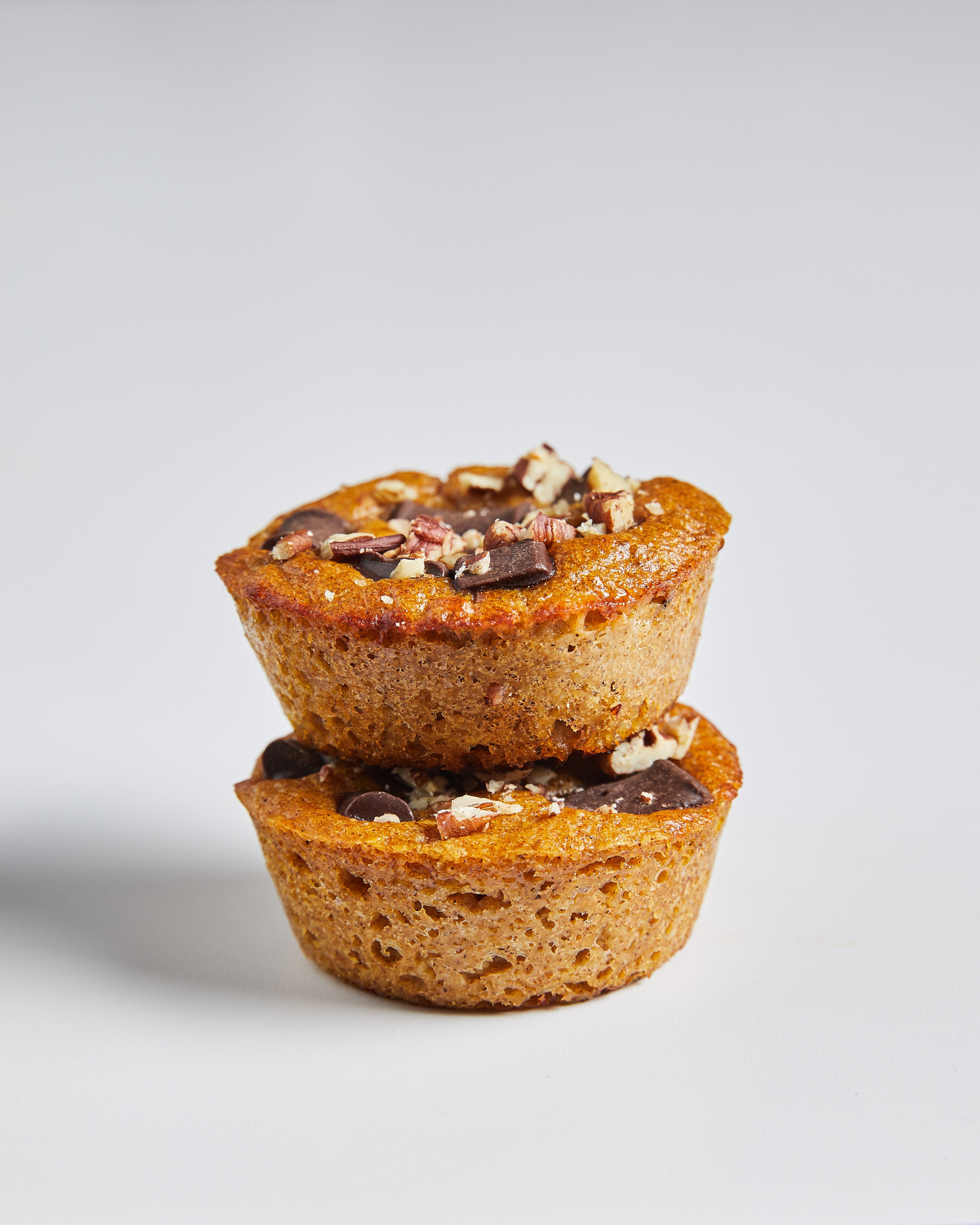 Two pumpkin muffins stacked on top of each other with toppings